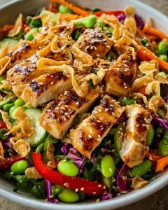 Gesunder Sesam-Hähnchensalat mit knackigem Gemüse und zartem Hähnchen.